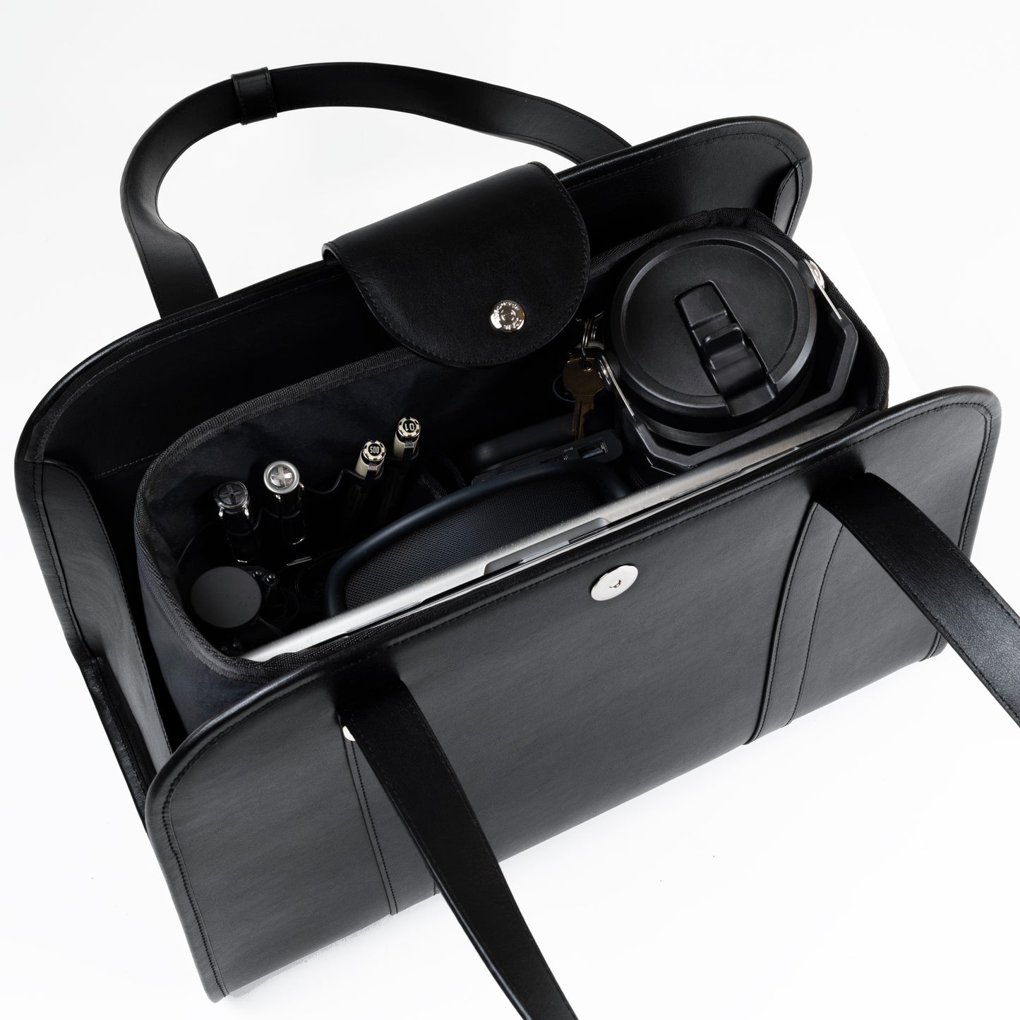 NOTCOMMON STUDIO’s Companion Tote Bag with an inner organizer, neatly storing daily essentials like a laptop, pens, a travel mug, and accessories.